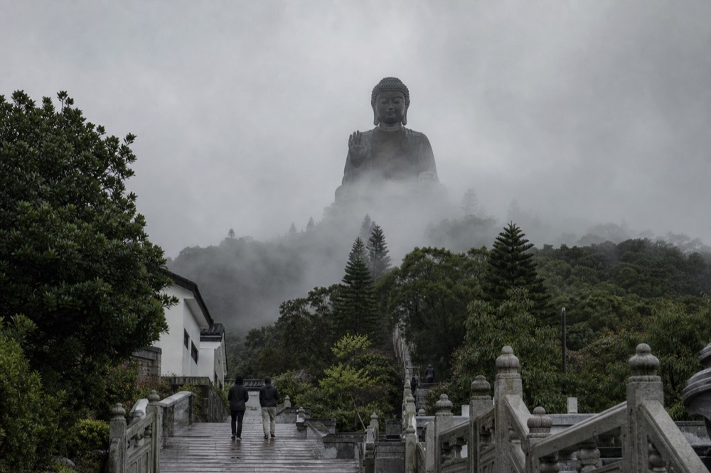 Low cloud drifting across the Lantau plateau above green slopes, no text, no logos, no people