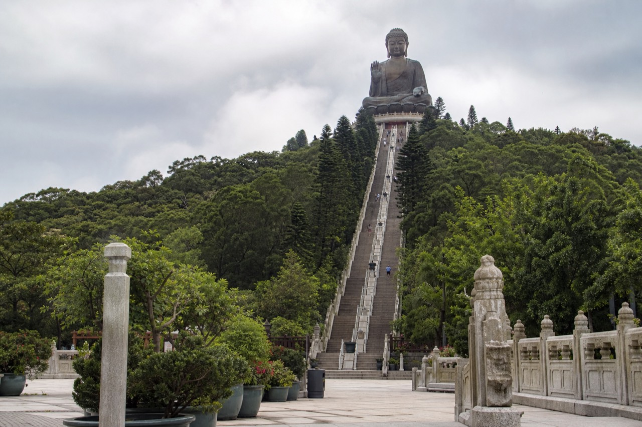 The Tian Tan Buddha seated above the Ngong Ping plateau under a wide sky, no text, no logos, no people