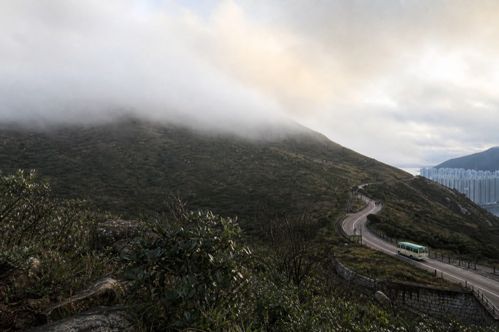 Low cloud drifting across high Lantau hillside terrain, no text, no logos, no people