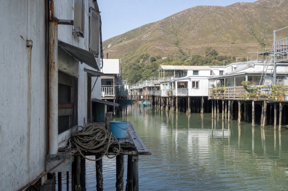 Stilt houses standing over a tidal waterway in a fishing village, no text, no logos, no people