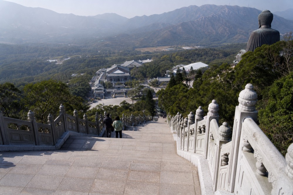 The 268-step approach to the Tian Tan Buddha with Po Lin Monastery rooftops below, no text, no logos, no people