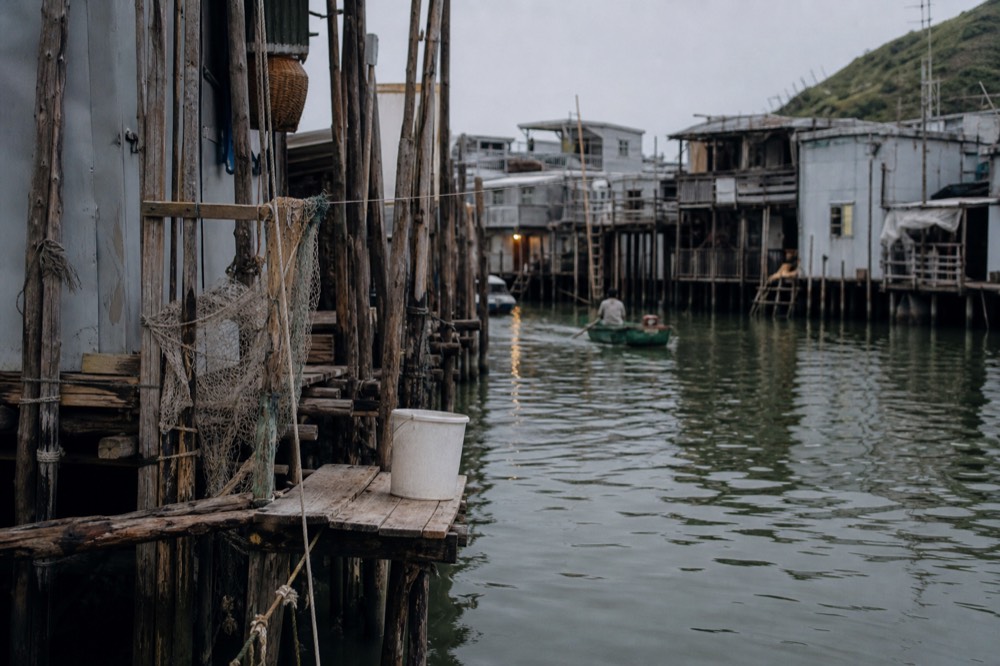 Stilt houses along the water channel at Tai O fishing village, no text, no logos, no people