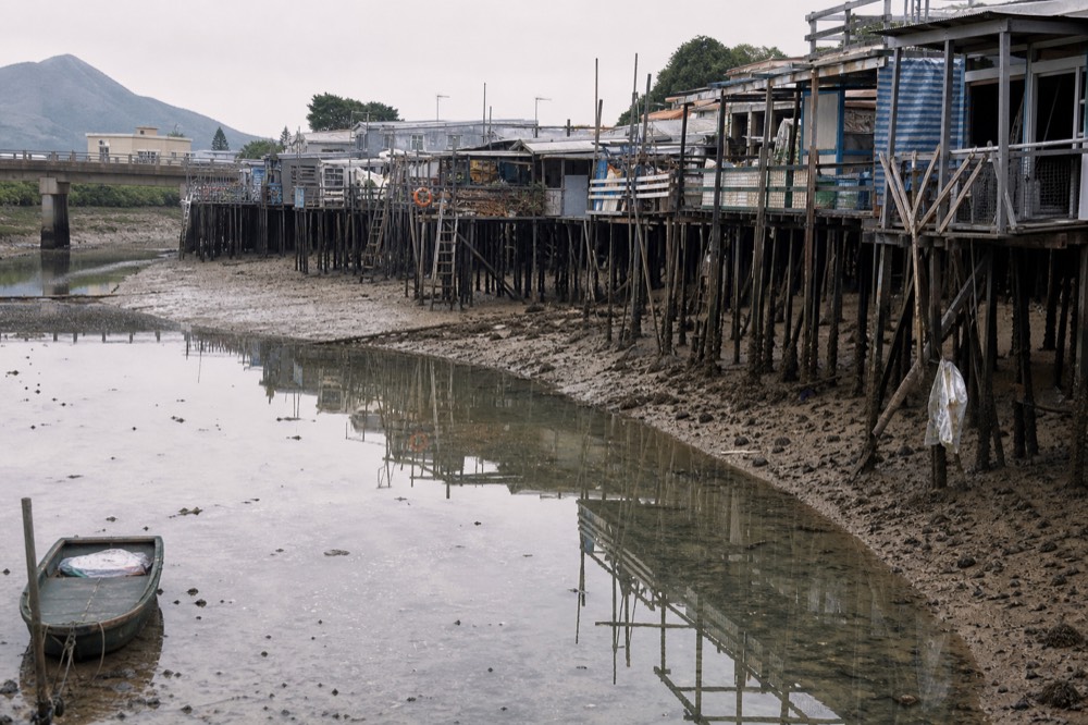 Tai O stilt houses reflected in the creek at low tide, no text, no logos, no people