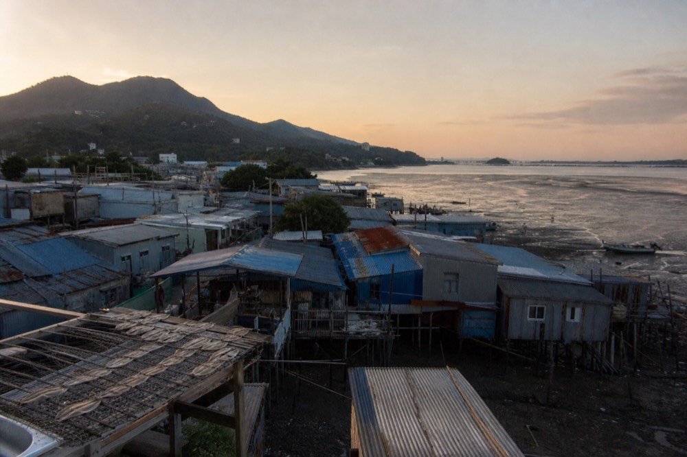 Wide view over Lantau's western coastline and village rooftops, no text, no logos, no people