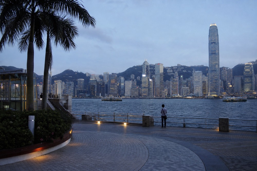 Hong Kong Island skyline across the harbour at dusk, no text, no logos, no people