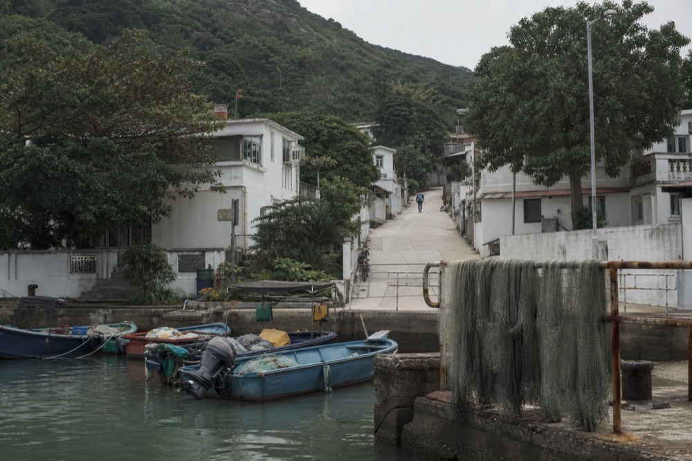 A quiet island waterfront with small boats and empty lanes in soft light, no text, no logos, no people