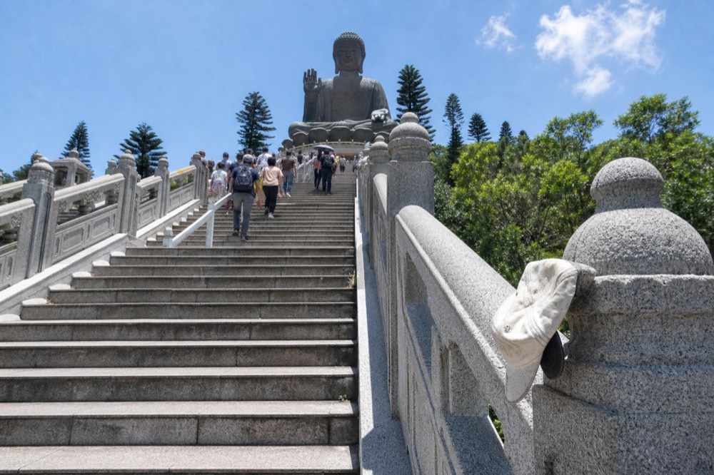 The stone staircase rising towards the seated bronze statue with railings and landings, no text, no logos, no people