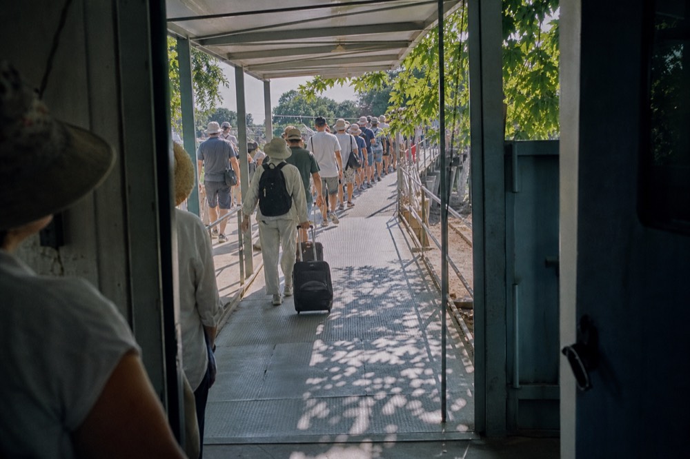 A queue of people waiting at an outdoor cable car boarding platform under a canopy, no text, no logos, no people.