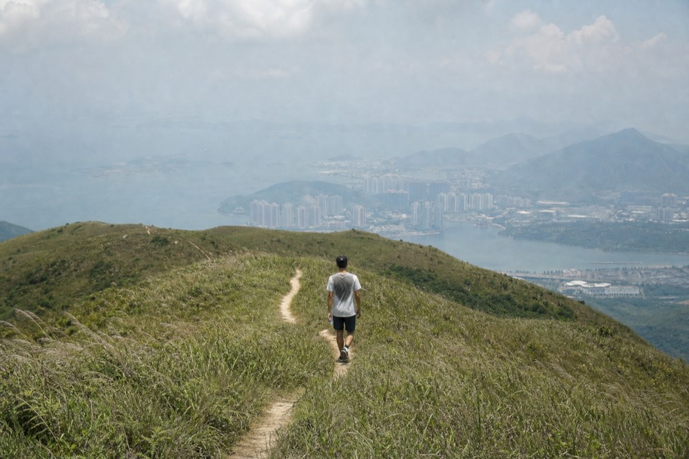 Hiker on an exposed trail with view of Lantau Island, no text, no logos, no people