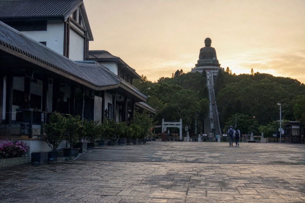 Disneyland castle in morning light with Big Buddha silhouette inset, no text, no logos, no people