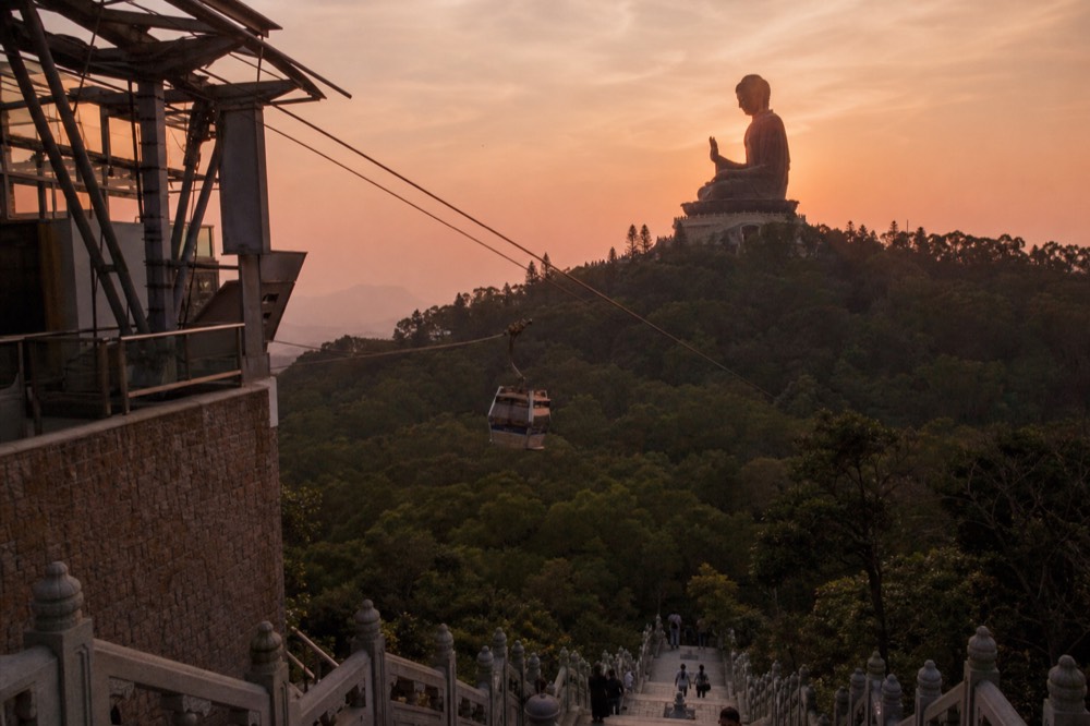 Big Buddha at sunset with cable car cabin in foreground, no text, no logos, no people
