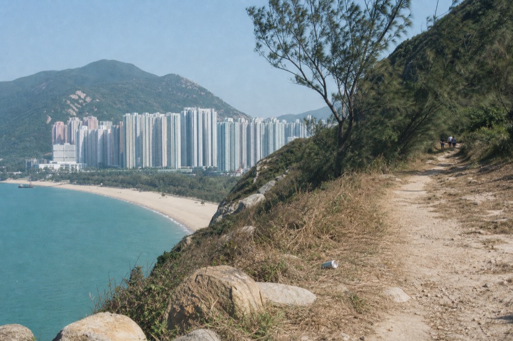 Coastal path above a long sandy beach with turquoise water, no text, no logos, no people