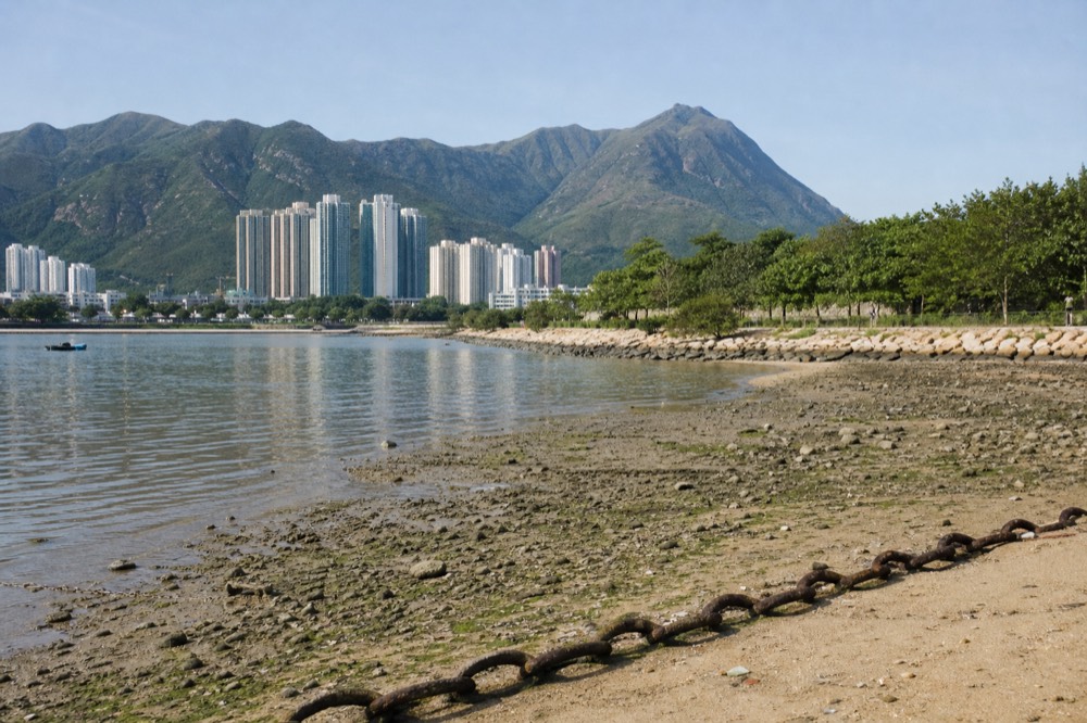 Green peaks of Lantau Island rising above the coastline, no text, no logos, no people
