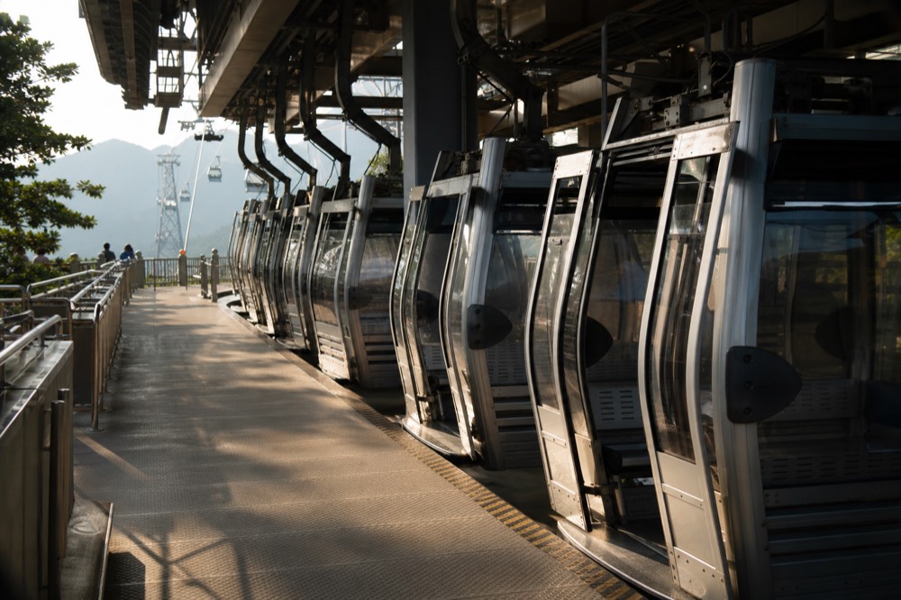Cable car cabins lined up at the Ngong Ping terminal platform, no text, no logos, no people