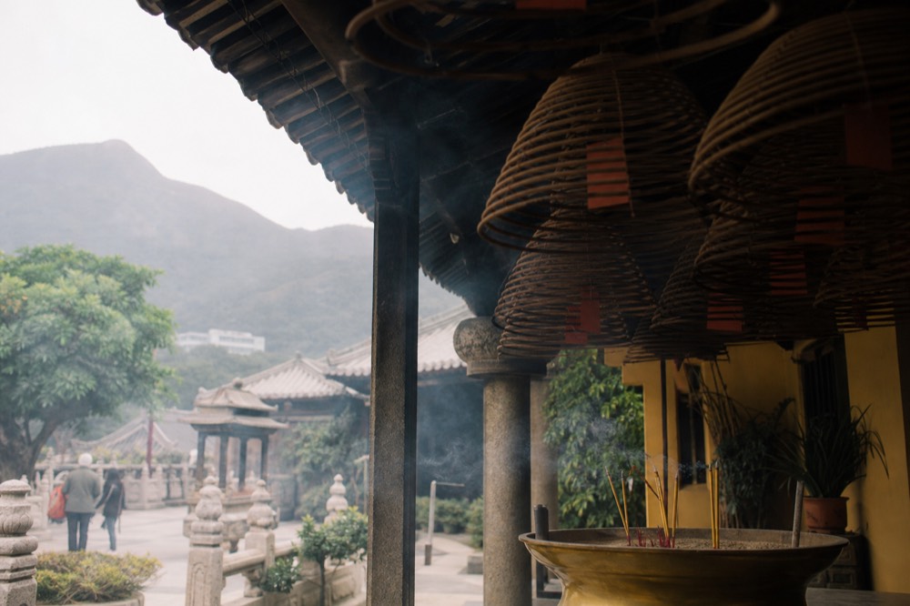Incense coils burning in the courtyard of Po Lin Monastery in morning light, no text, no logos, no people
