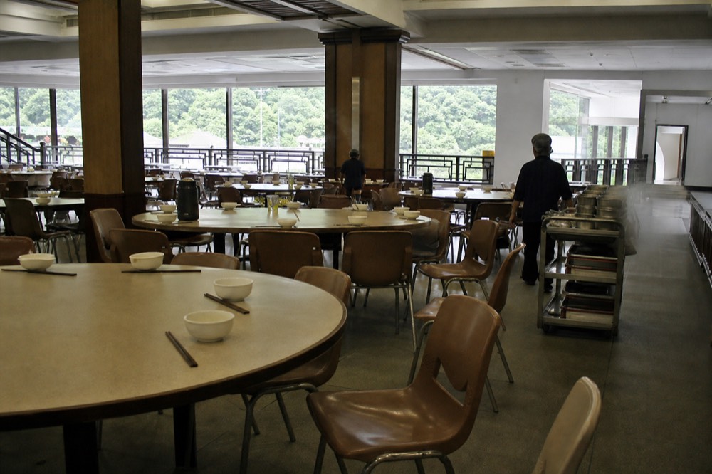 Communal dining tables set for a vegetarian meal in a monastery hall, no text, no logos, no people