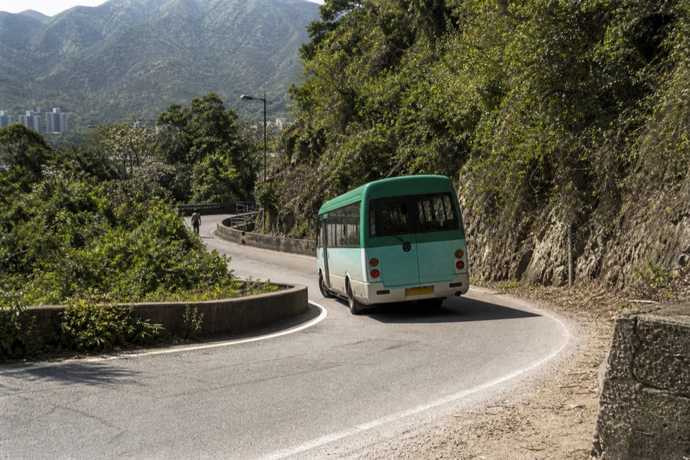A New Lantao Bus travelling the winding road between Ngong Ping and Tai O on Lantau Island, no text, no logos, no people