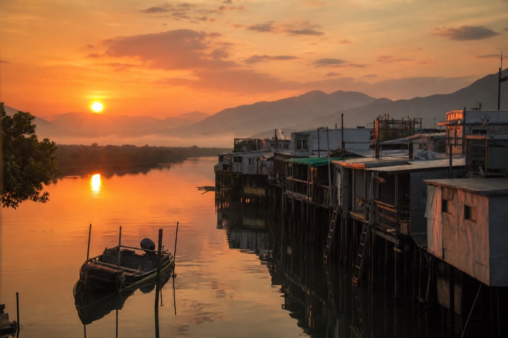Sunset light over the water channel and stilt houses of Tai O fishing village, no text, no logos, no people