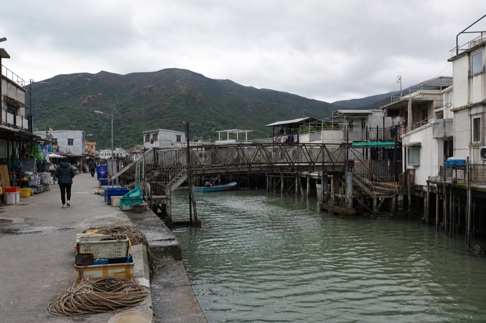The iron footbridge over the water channel in Tai O fishing village with stilt houses on both sides, no text, no logos, no people