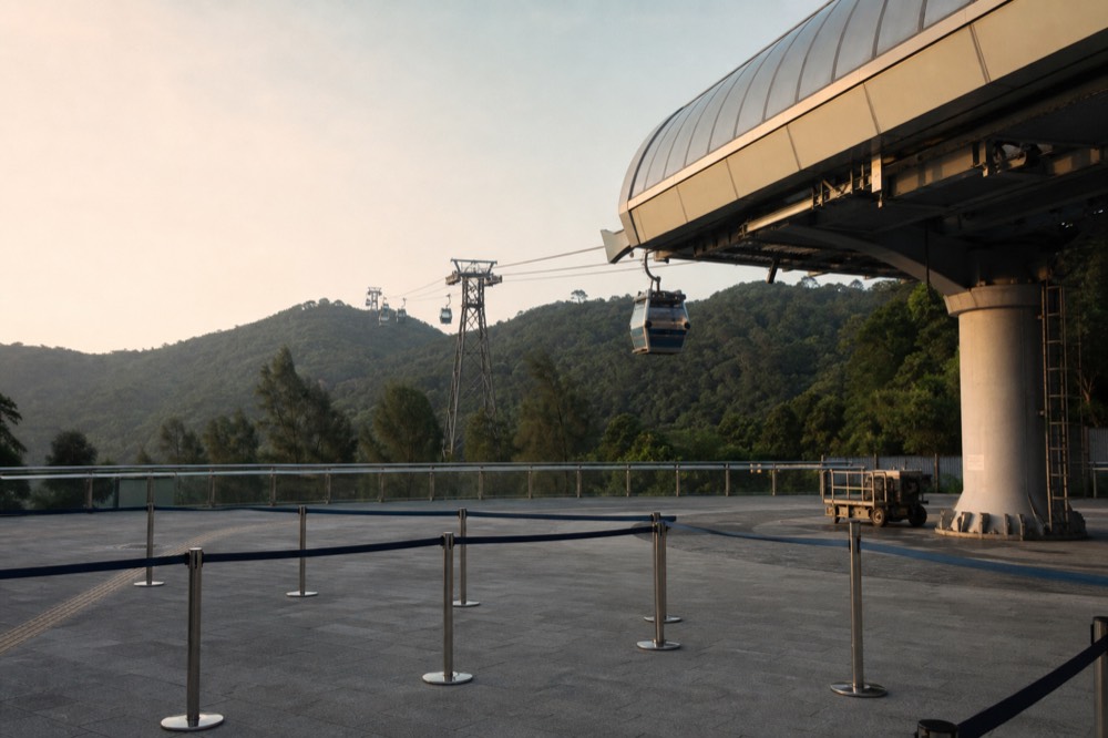Tung Chung Cable Car Terminal with cabins departing towards the hills, no text, no logos, no people